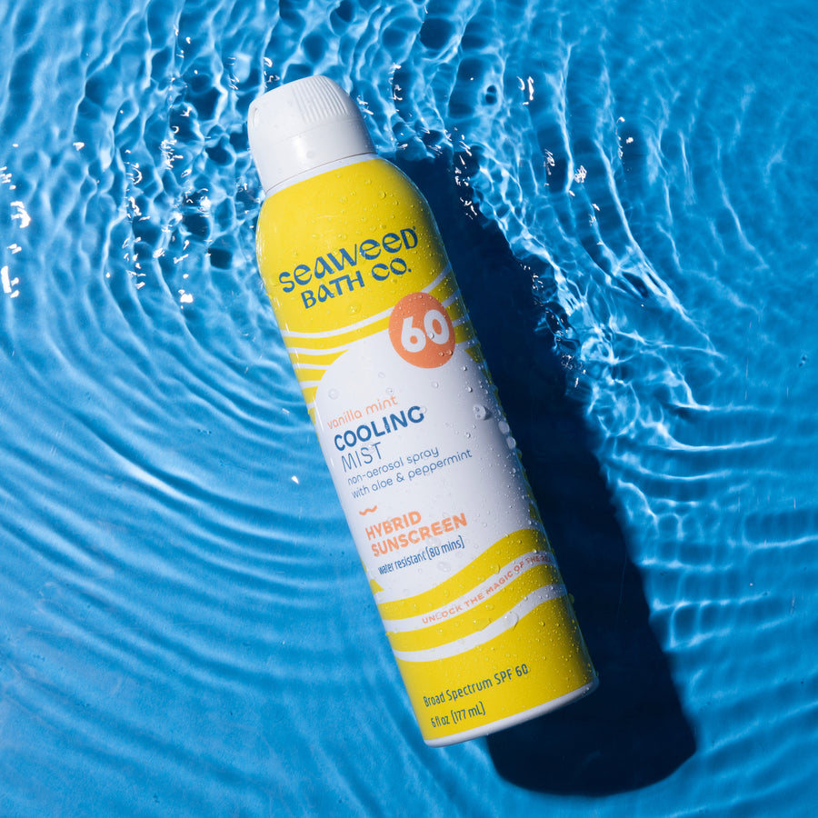 Cooling Mist Sport+ Spray SPF 60 Sunscreen can laying flat in rippling water on a blue background.