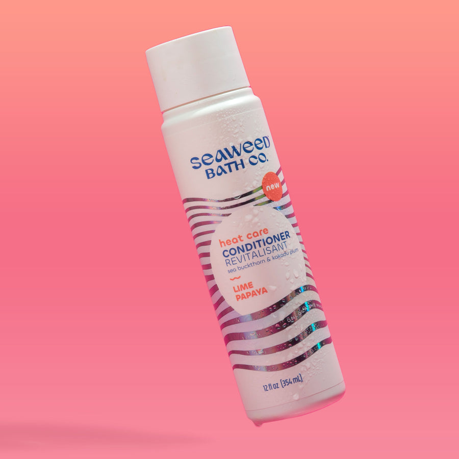 Seaweed Bath Co. Heat Care Conditioner bottle floating on pink background.