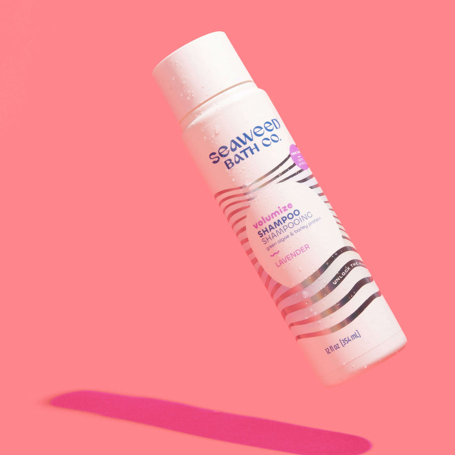 Volumize Shampoo in Lavender floating on pink background. Seaweed Bath Co.
